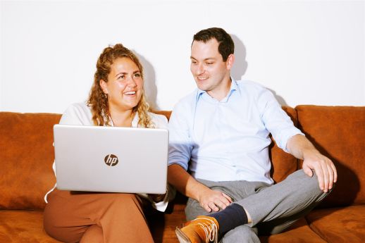 Afgestudeerde met laptop op bank