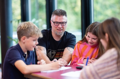 Docent legt iets uit aan een groepje leerlingen