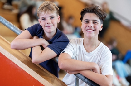 Twee jongens op de trap van het schoolgebouw