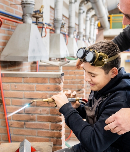 Docent helpt een leerling in het technieklokaal