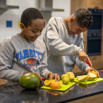 kinderen snijden groente en fruit