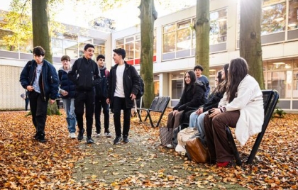 Leerlingen voor de ingang van OVMZ in een bosrijke omgeving