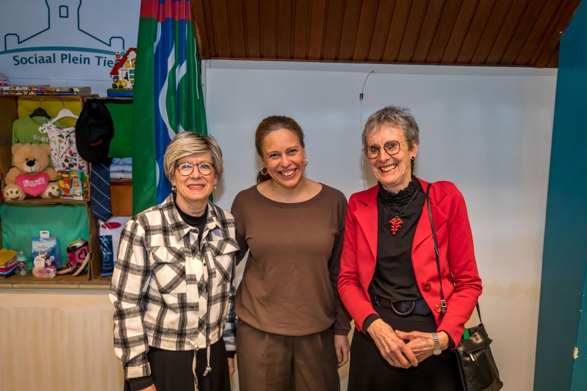 3 vrouwen staan naast elkaar. Minister Carola Schouten van Armoedebeleid staat in het midden omringt door Miek en Reina van stichting Leergeld West Betuwe.