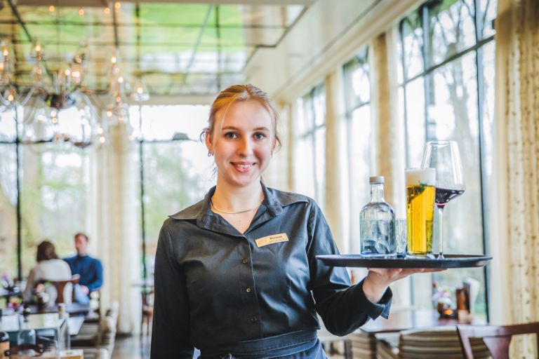 Gastvrouw Malissa met dienblad restaurant Putten Kasteel De Vanenburg