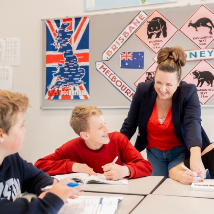 Docent kijkt met een leerling mee in zijn schrift