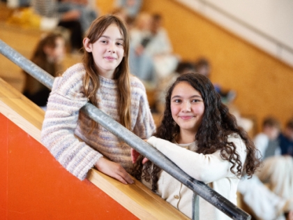 Twee leerlingen staan op de trap van het schoolgebouw