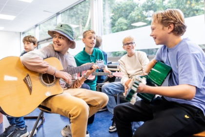 Decoratief. Vier leerlingen in kring tijdens muziekles.