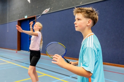 Twee leerlingen badmintonnen in de gymzaal