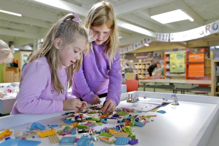 Meiden spelen met lego op school.