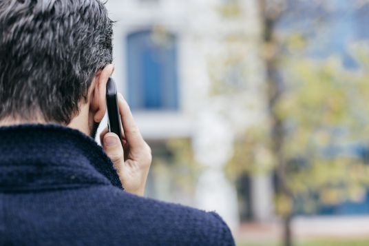 rear-view-of-man-using-mobile-telephone-2024-06-21-18-22-05-utc