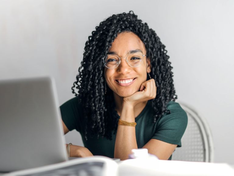 Vrolijke vrouw achter laptop.