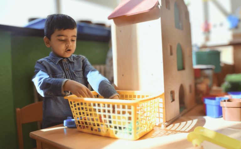 Kleuter speelt met een poppenhuis