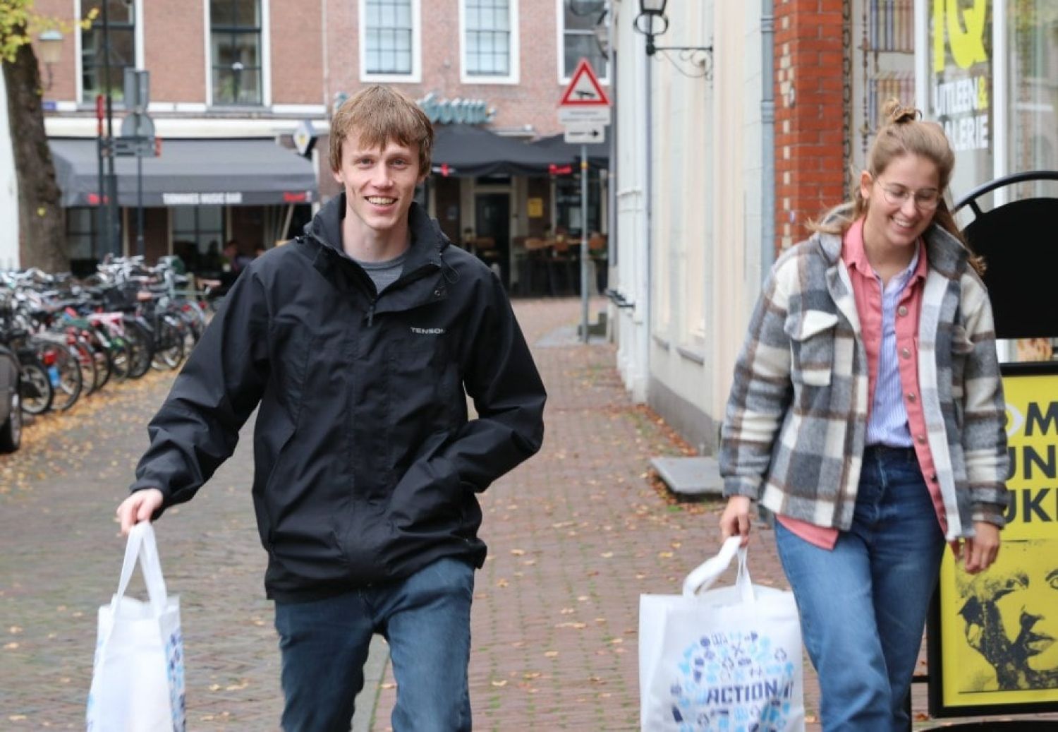 twee jonge vrijwilligers doen boodschappen voor een maatje