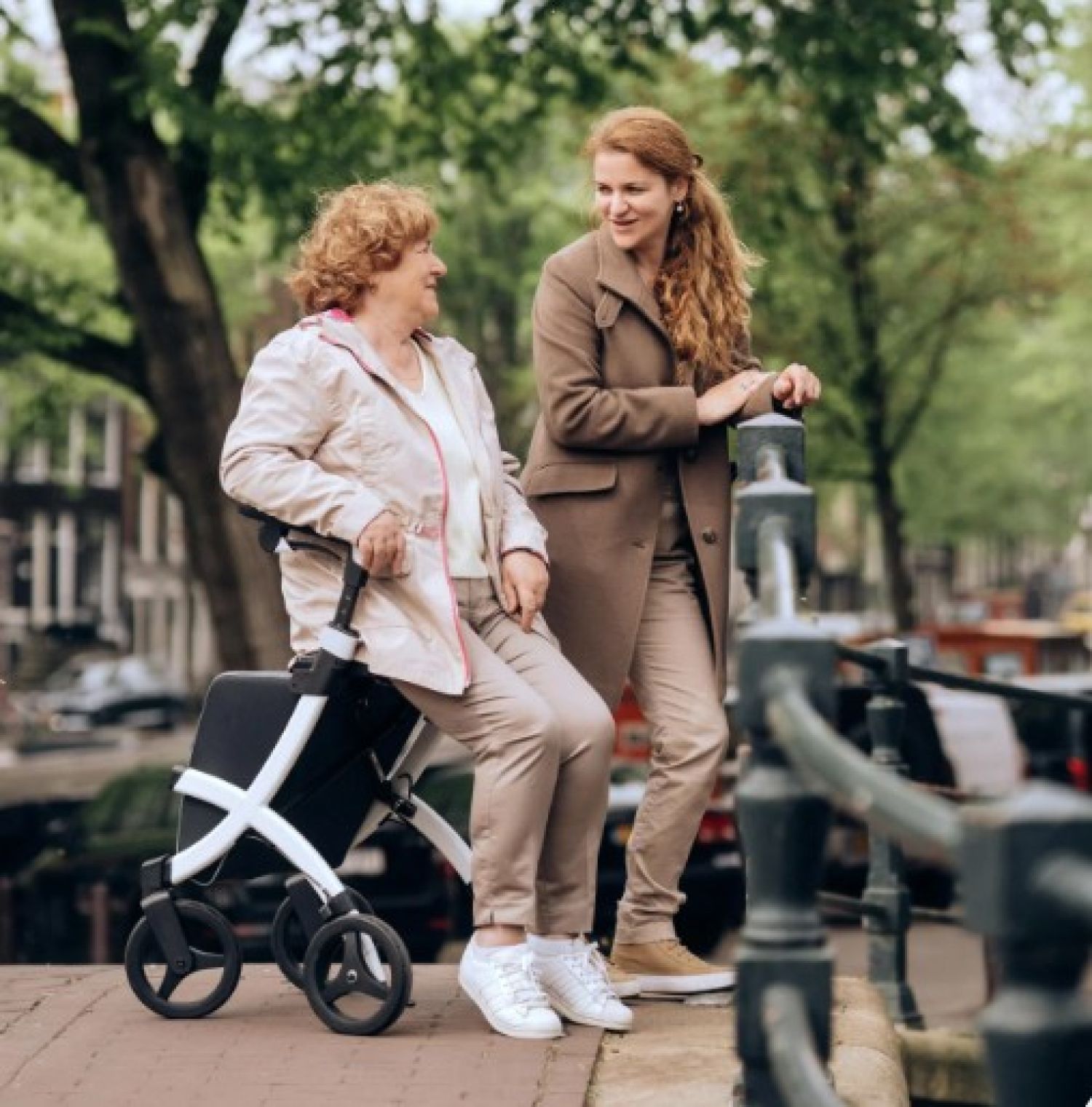 Maatjescontact: jonge meid wandelt met oudere dame met rollator