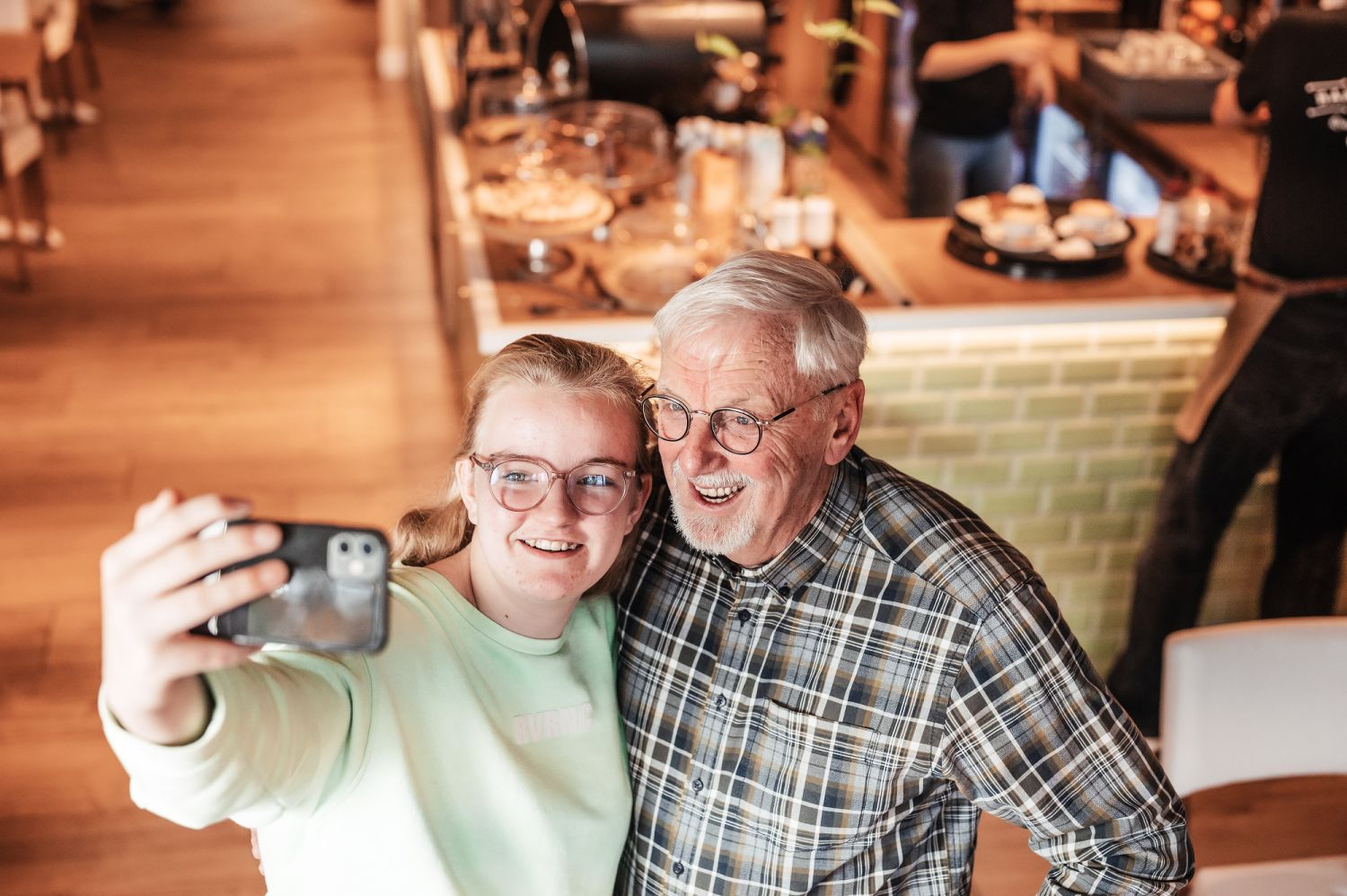 Jonge vrijwilliger met oudere vrijwilliger op de foto
