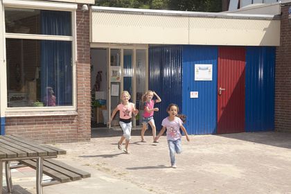 Kinderen rennen op schoolplein.