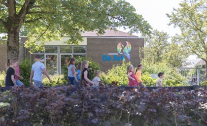 Kinderen voor het schoolgebouw.