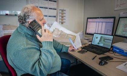 Uitvoerder bellend aan zijn bureau