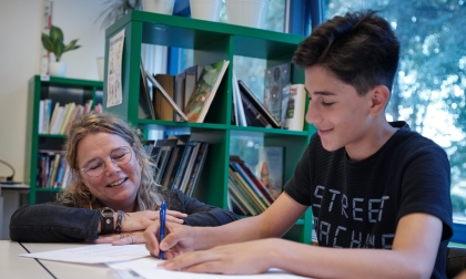 Ithaka-leerling die aan het werk is in een schrift.