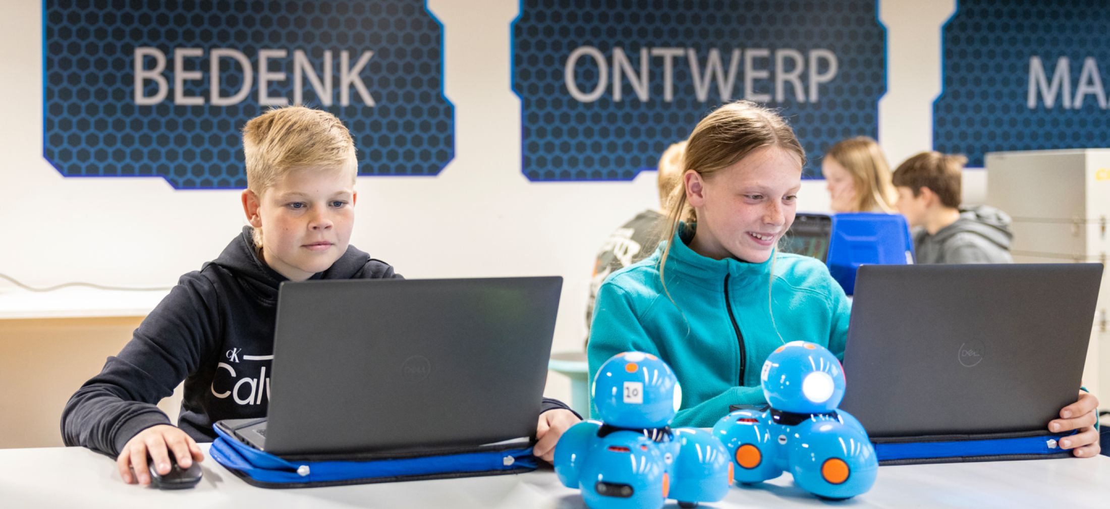 Jongen en meisje achter laptops