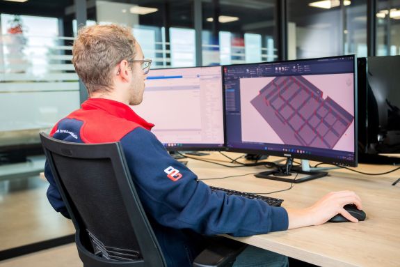 Medewerker werkt een 3D-tekening uit op de computer