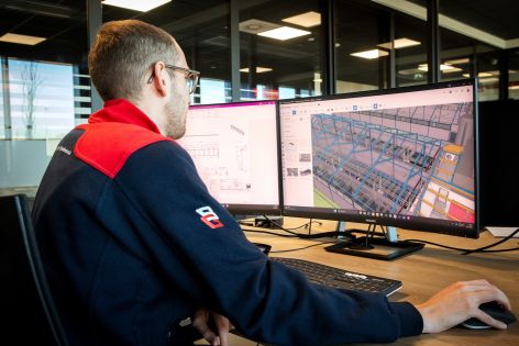 Medewerker werkt een 3D-tekening uit op de computer Medewerker werkt een 3D-tekening uit op de computer