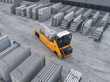 Betonlader verplaatst prefab betonwanden op het terrein