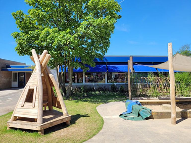 kleine plein Franciscusschool Kleine plein met een houten hut en een zandbak