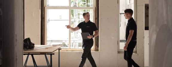 a team of mechanics in front of their vans, zoomed out, bright day, in canada