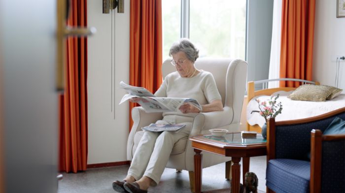 Vrouwelijke bewoner in appartement verpleeghuis Riederborgh krant lezen Mevrouw zit in haar appartement in verpleeghuis Riederborgh