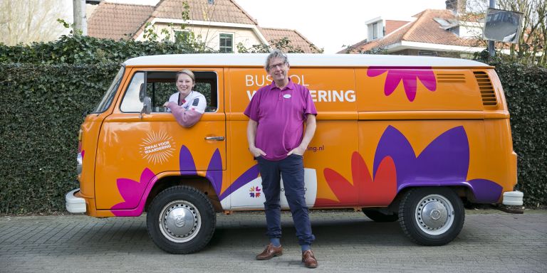 Bus vol waardering met twee medewerkers dagbesteding welzijn vacature thuiszorg verpleeghuiszorg algemeen ondersteuning huishouden uniform Oud oranje volkswagen busje als bus vol waardering van Lelie zorggroep