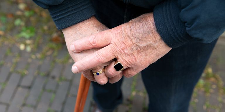 Handen client stok buiten Oude handen met zegelring leunen op een stok