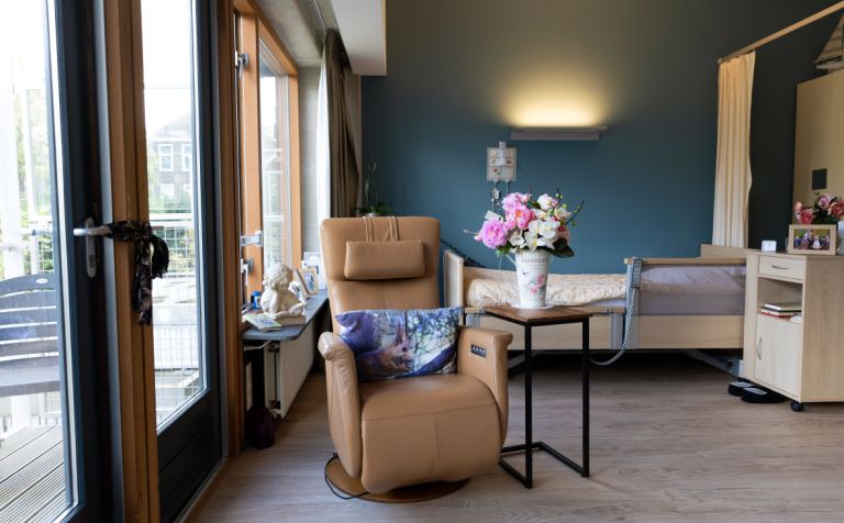 Interieur appartement slaapkamer stoel - web Klassiek ingerichte slaapkamer met een bed en stoel in een appartement in een verpleeghuis