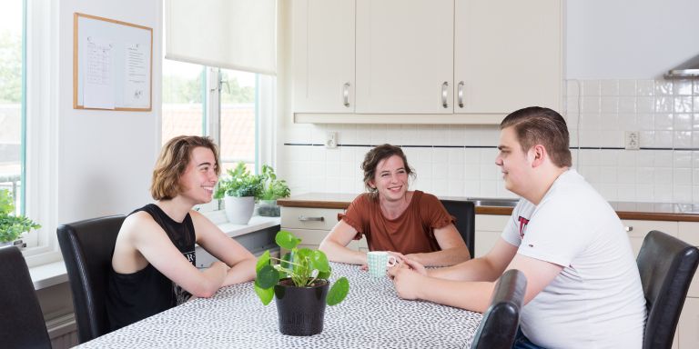 Jongeren hulpverlener in gesprek De Reling Twee jongeren en vrouwelijke hulpverlener zitten aan tafel en zijn in samen gesprek