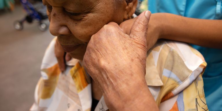 Cliënt verpleeghuis Atrium warm moment handen samen palliatieve zorg Cliënt verpleeghuis Atrium houdt hand vast van medewerker