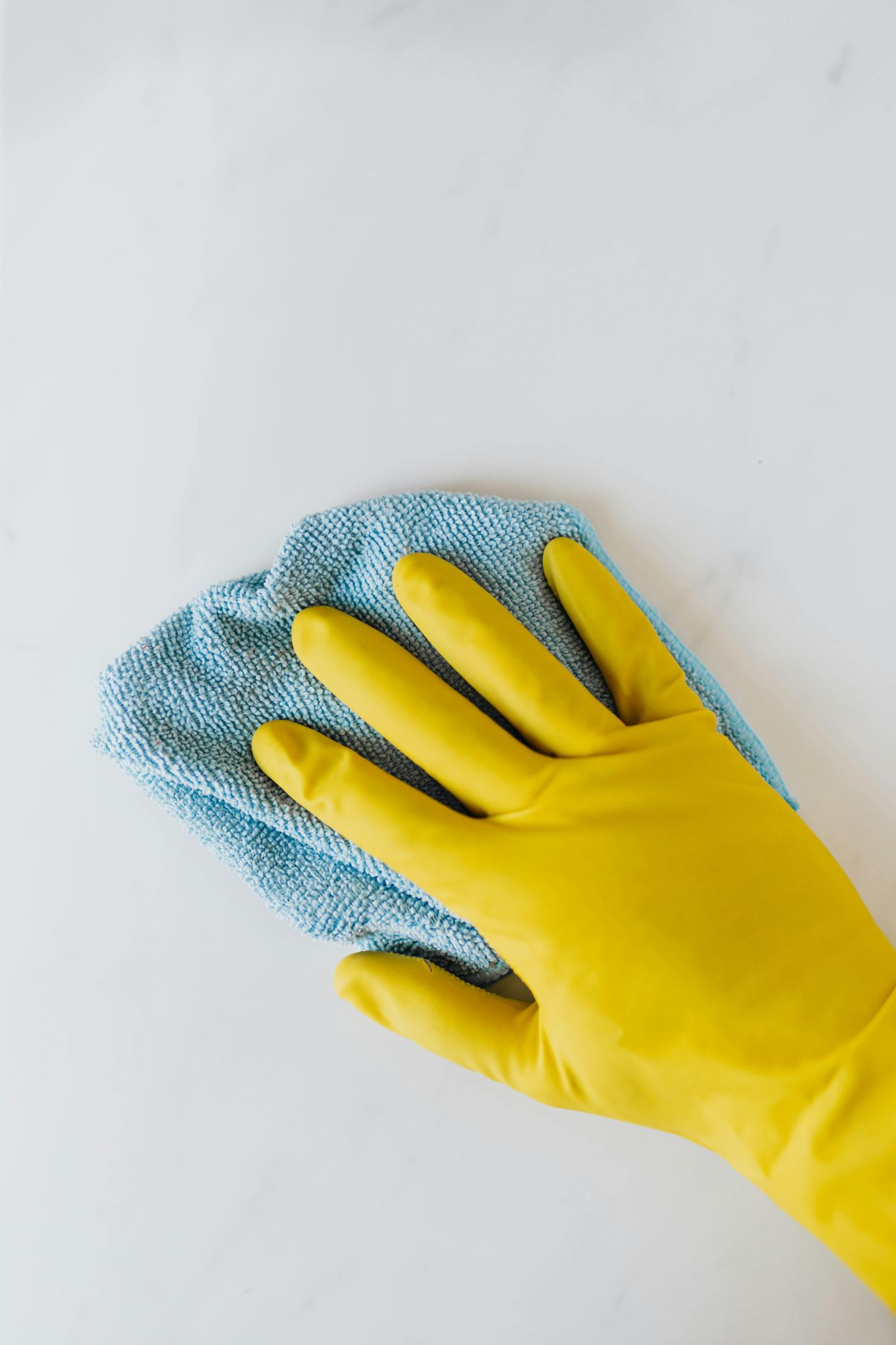 Vacature voor schoonmaak of hulp bij huishouden bij christelijke zorgorganisatie Lelie zorggroep stockfoto Een hand in een schoonmaakhandschoen met een spuitbus met schoonmaakmiddel